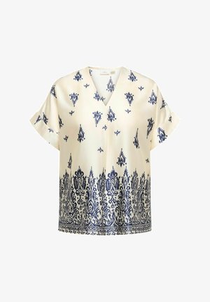 Cream blouse with navy blue damask pattern, short sleeves, and V-neck. Smooth fabric with intricate detailing at the hemline.