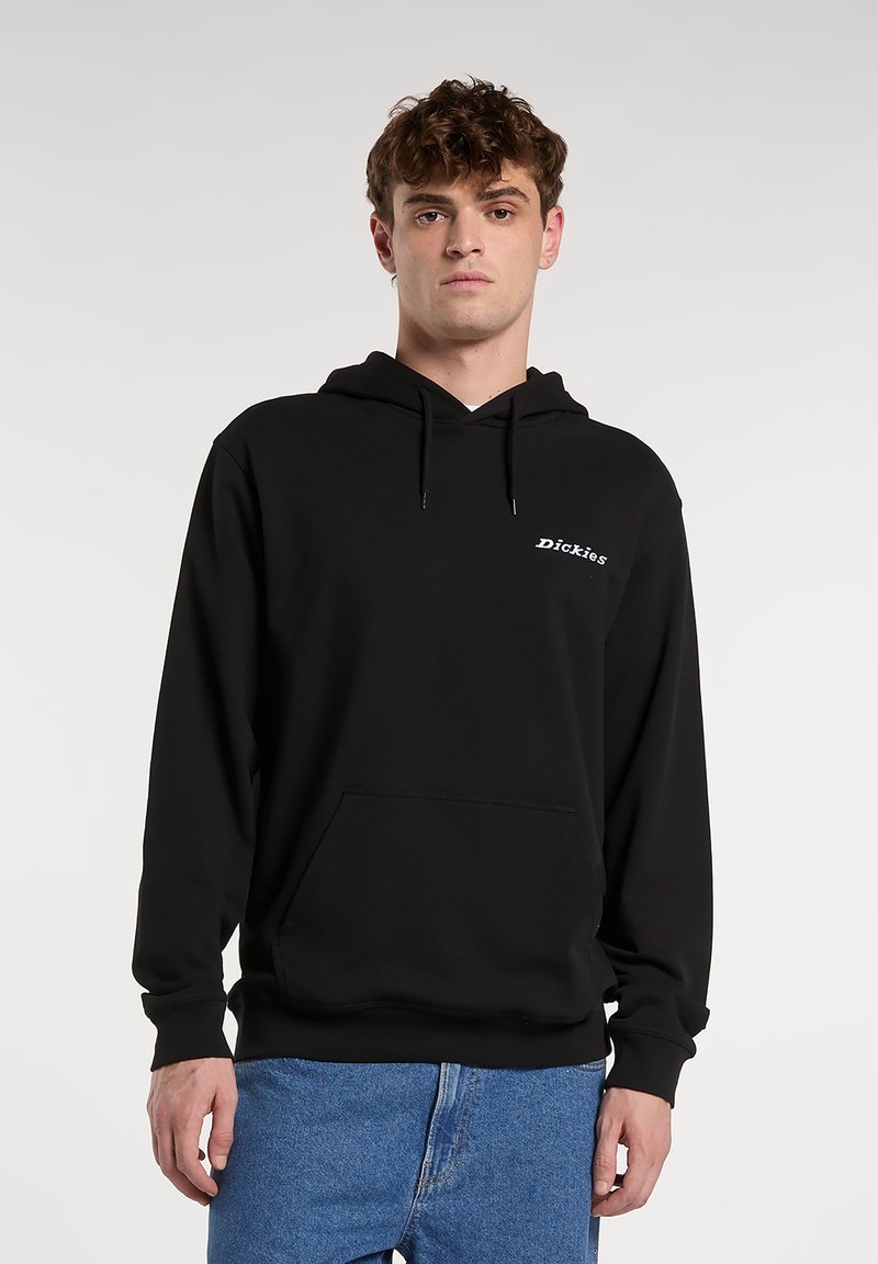 Felpa nera in misto cotone, con tasca frontale, cappuccio con coulisse e logo bianco sul petto. Modello con jeans blu.