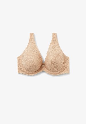 Soutien-gorge en dentelle de couleur chair avec des bonnets triangulaires, des bords festonnés et un nœud décoratif au centre. Présente des motifs floraux intricats.