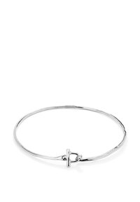 Pulsera de brazalete de plata con un cierre delicado que presenta un pequeño acento de cristal redondo, exhibida sobre un fondo blanco.