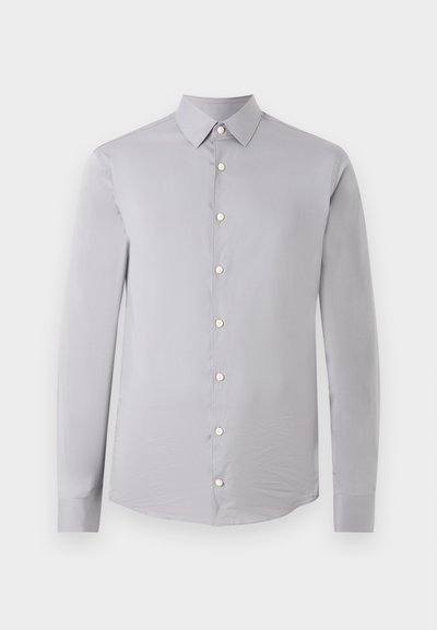 Ανοιχτό γκρι πουκάμισο με μακριά μανίκια, κουμπιά και μυτερό γιακά, παρουσιασμένο σε απλό λευκό φόντο.