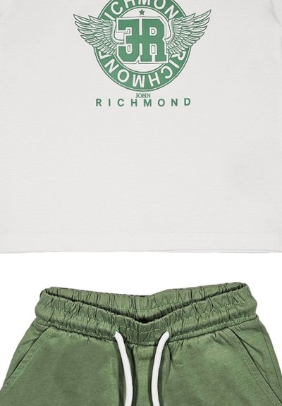 T-shirt bianco con logo grafico verde raffigurante ali e testo; abbinata a pantaloni della tuta verdi con vita elasticizzata e cordoncino.