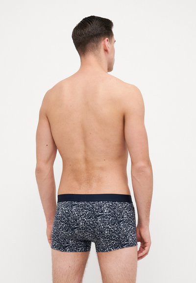 Boxers bleu marine à motifs avec un tissu texturé, présentant une taille unie foncée et un design coupé mi-cuisse.