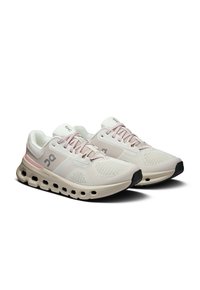 Beige és rózsaszín könnyű futócipő pár, lélegző hálós anyaggal, párnázott talppal és hatszögletű légnyílásokkal a középtalpon.