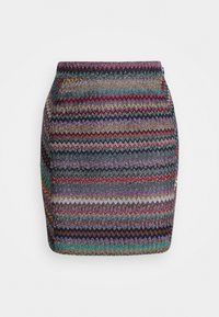 Falda lápiz de punto con un patrón de zigzag en colores vibrantes, incluyendo rojo, púrpura y verde azulado, con una cinturilla para una silueta ajustada.