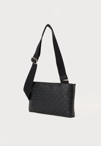 Sort skuldertaske med et tekstureret mønster, der har et diagonalt design. Den har en sort rem og en slank form med en glat overflade.