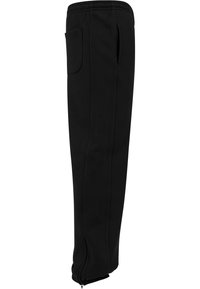 Svarta joggers med elastisk midja, sidoficka och zippered fållar. Tillverkade av ett mjukt, hållbart tyg med en slät yta.