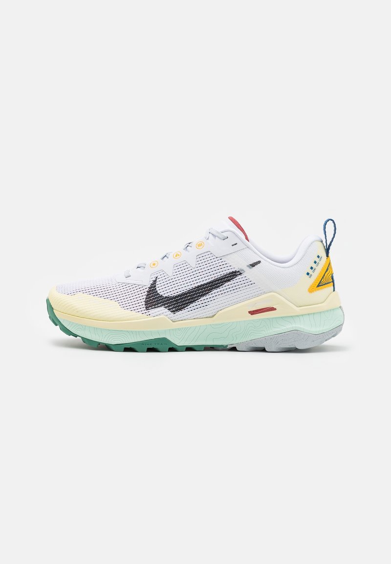 Zapatillas Nike con parte superior de malla blanca, swoosh negro, suela exterior verde menta, acento amarillo y detalles en rojo y azul.