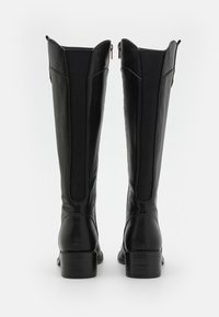 Bottes noires à mi-mollet avec une finition en cuir lisse, des panneaux supérieurs texturés, des zips sur les côtés et des talons empilés.
