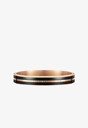 Bague en métal rose doré avec deux bandes en émail noir et "DANIEL WELLINGTON" gravé sur l'anneau.
