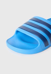 Μπλε σα�γιονάρα slide με υφασμένη σόλα και φαρδιά λουρί με σκούρες μπλε ρίγες. Κατασκευασμένη από εύκαμπτο συνθετικό υλικό.