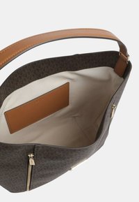 Borsa tote scura con motivo e manico in pelle color cuoio e dettagli in tinta. Interno con fodera beige e piccola tasca color cuoio, tessuto testurizzato.