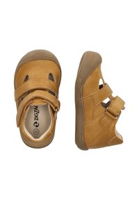 Braune Lederkinderschuhe mit zwei verstellbaren Klettverschlüssen, runder Zehenpartie und ausgeschnittenen Details. Gummisohle mit griffiger Textur.