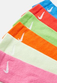 Bunte Socken in Pink, Grün, Orange, Rot und Blau mit gerippter Textur und weißem Nike-Logo auf jeder Socke.