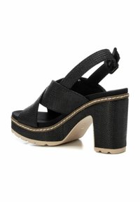 Sandalias de plataforma negras con correas de tela texturizada, un tacón grueso y una puntera redondeada. Incluyen ajuste con hebilla y una suela en contraste.