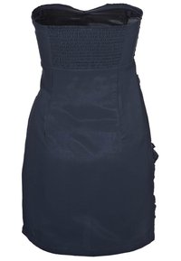 Marinblå klänning utan axelremmar med smockad liv, figurnära silhuett och subtil lyster. Sidan har volangdetaljer längs fållen.