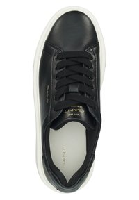 Must musta tennisjalanike ümmarguse ninaga, tooniga nööridega, valge kummist tallaga ning diskreetse kuldse brändinguga keeles ja küljel. Sile tekstuur.