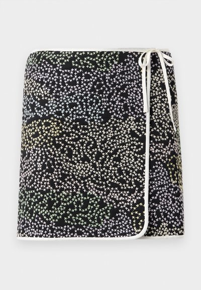 Fustă neagră cu împachetare, având un model cu stele multicolore în nuanțe de galben pastelat, verde și albastru, accentuată cu margine și fundiță albă.