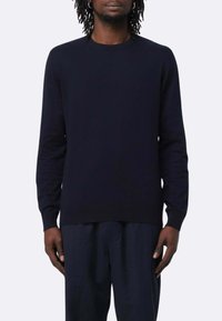 Maglione blu navy a collo rotondo con maniche lunghe, realizzato in materiale morbido, caratterizzato da polsini e bordo a coste per un look aderente.