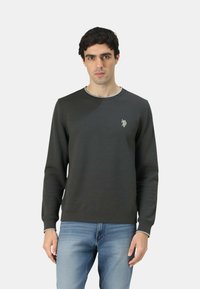 Felpa grigio scuro con scollo rotondo e maniche lunghe, caratterizzata da un sottile logo ricamato sul lato sinistro del petto. Vestibilità casual.