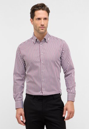 Chemise à bouton rouge et blanche à rayures avec manches longues. Col classique et poignets, coupe ajustée, fabriquée en tissu léger.