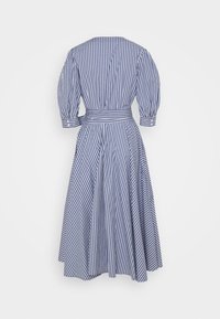 Rutig klänning i marinblått och vitt, med puffärmar, en figurnära midja med bälte och en flödande kjol. Bakvy visas.