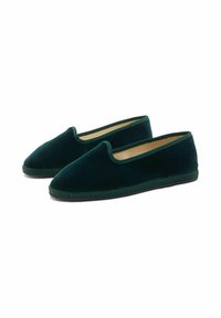 Un paio di scarpe slip-on in velluto verde scuro con punte arrotondate e suole cucite su uno sfondo bianco.