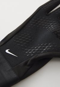 Svart atletisk hanske med teksturert grep overflate, med en hvit Nike-logo. Laget av lett og fleksibelt materiale med en tettsittende passform.