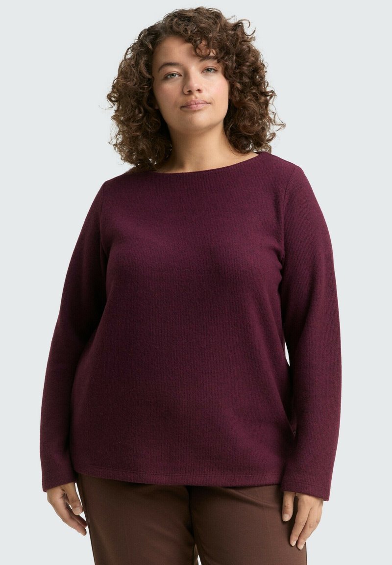 Bordowy sweter z długimi rękawami, okrągłym dekoltem, strukturalnym materiałem, luźnym fasonem, zestawiony z brązowymi spodniami. Prosty design, bez widocznych wzorów.