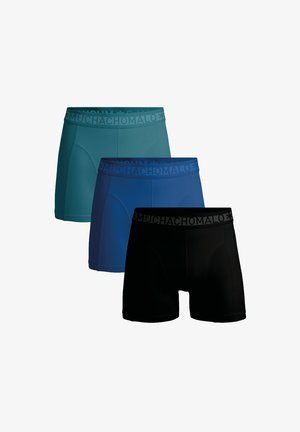 Trīs bokseršortu pāri teal, zilā un melnā krāsā. Vienkrāsaini, ar ciešu piegriezumu un elastīgu jostasvīri, kurā ir teksts "MUCHACHO MALO."