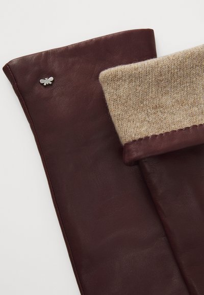 Burgunderfargede lærhansker med en strikket beige mansjett og et lite sølvfarget bieemblem på siden. Glatt tekstur med sømte kanter.