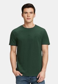 T-shirt in cotone verde con colletto girocollo classico, maniche corte e design aderente. Presenta un logo sottile sul petto.