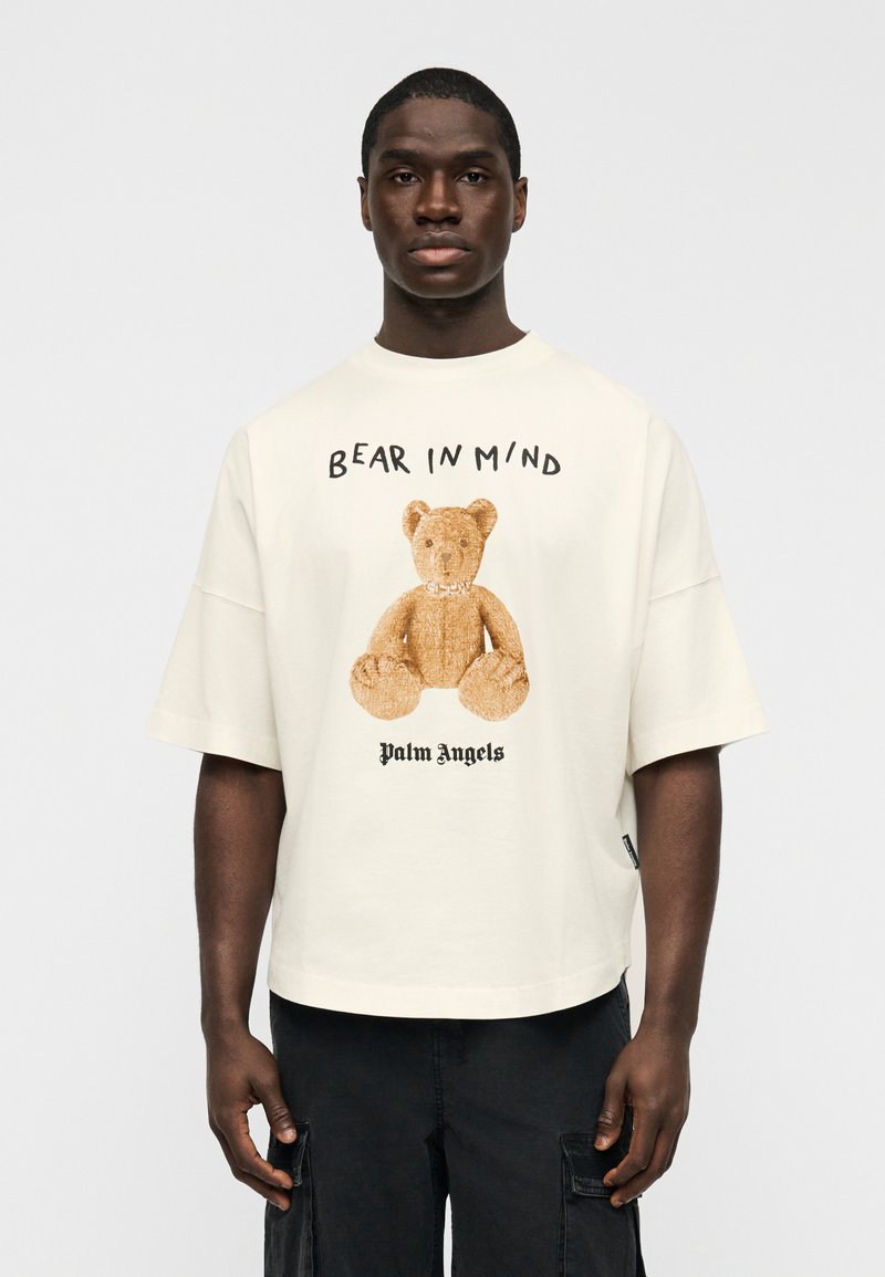 Κοντομάνικο T-shirt σε κρεμ απόχρωση με γραφικό αρκουδάκι και το κείμενο "BEAR IN MIND", καθώς και τη σήμανση "Palm Angels", σε χαλαρή εφαρμογή.