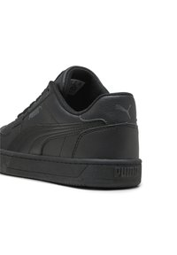 Baskets en cuir noir avec une finition texturée, dotées d'un bout arrondi, d'un système de laçage et d'un logo embossé sur le talon et sur le côté.