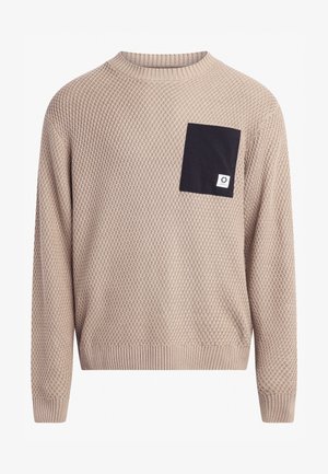 Beige knit sweater with a textured pattern, round neckline, and ribbed cuffs. Features a black pocket with a small logo detail.