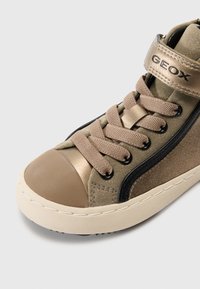 Høyhælte sneaker i grå og beige. Har et teksturert stoff og glatte aksenter, med beige lisser og en gummitåhette. Geox-merke synlig.