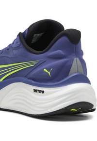Puma trkaći tenisice s plavim gornjim dijelom i zelenim detaljima, teksturiranim materijalom, podstavljenom bijelom potplatom i istaknutim logotipom "NITRO".