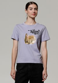 Lavendelfarbenes Baumwoll-T-Shirt mit einem Grafikdesign eines schlafenden Kaninchens und dem Text "ich hasse dich!" in Schwarz, mit kurzen Ärmeln und rundem Ausschnitt.