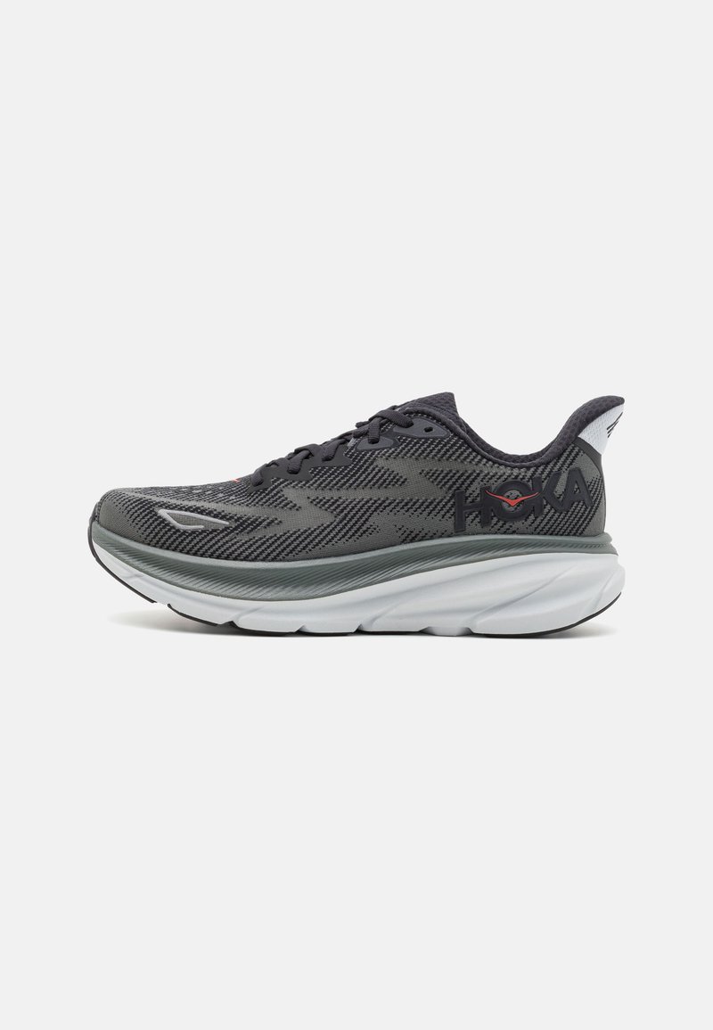 Sport shoe featuring a black and gray patterned mesh upper, cushioned white midsole, and round toe design with lace-up closure.