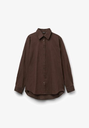 Camisa marrón oscuro de manga larga con botones, cuello puntiagudo y bajo curvo, mostrada extendida sobre un fondo blanco.