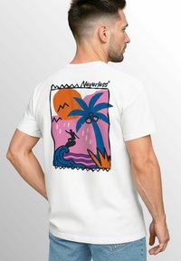 White short-sleeve t-shirt with a colorful graphic on the back featuring a surfer, palm tree, sun, and abstract waves against a pink background.