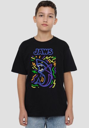 Black cotton t-shirt featuring a colorful graphic of a shark and the word "JAWS" in bold letters. Includes abstract, wavy accents.