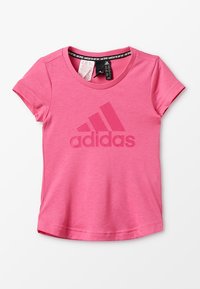 Camiseta de manga corta rosa, hecha de una tela suave, que presenta un gran logo tonal de Adidas en la parte frontal y un cuello redondo.