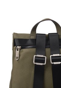 Mochila verde oliva hecha de tela texturizada con un asa superior, correas ajustables negras y un bolsillo con cremallera plateada.