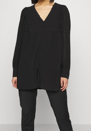 Schwarze Bluse mit langen Ärmeln und V-Ausschnitt, texturiertem Stoff, dezenter Knopfleiste vorne und Rüschendetails an den Schultern.