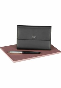 Portafoglio in pelle nera dal design elegante con logo JOOP! Posato su una superficie rosa accanto a una penna argento e nera.