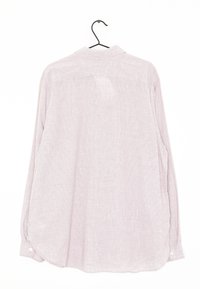 Camisa de manga larga en rosa claro con un sutil patrón de cuadros, con cuello y puños abotonados, colgando de un gancho negro.