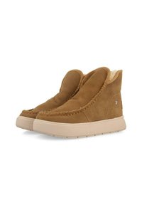 Bottines en daim marron avec un design cousu, doublure en peluche et une épaisse semelle en caoutchouc beige. Présentent une texture lisse et un bout arrondi.