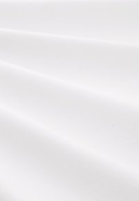 Tela blanca que muestra un patrón texturizado y tejido con suaves caídas, resaltando su superficie lisa y color uniforme.