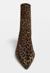 Pointed-toe ankle boot with brown and black leopard print fabric and visible vertical stitching down the center front.